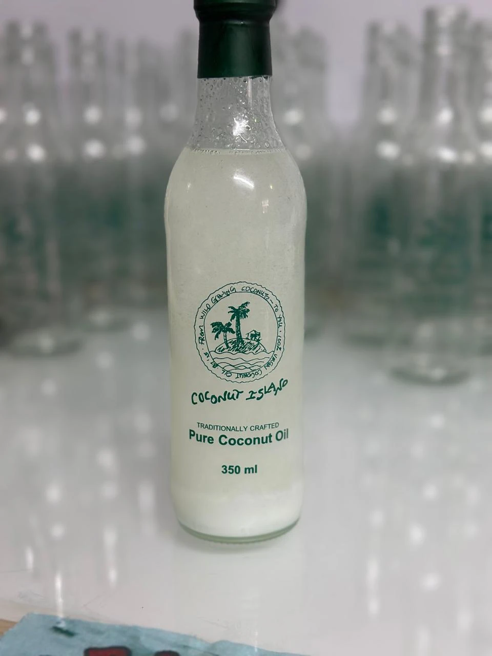 Clear bottle bearing a green Coconut Island emblem and product lettering.