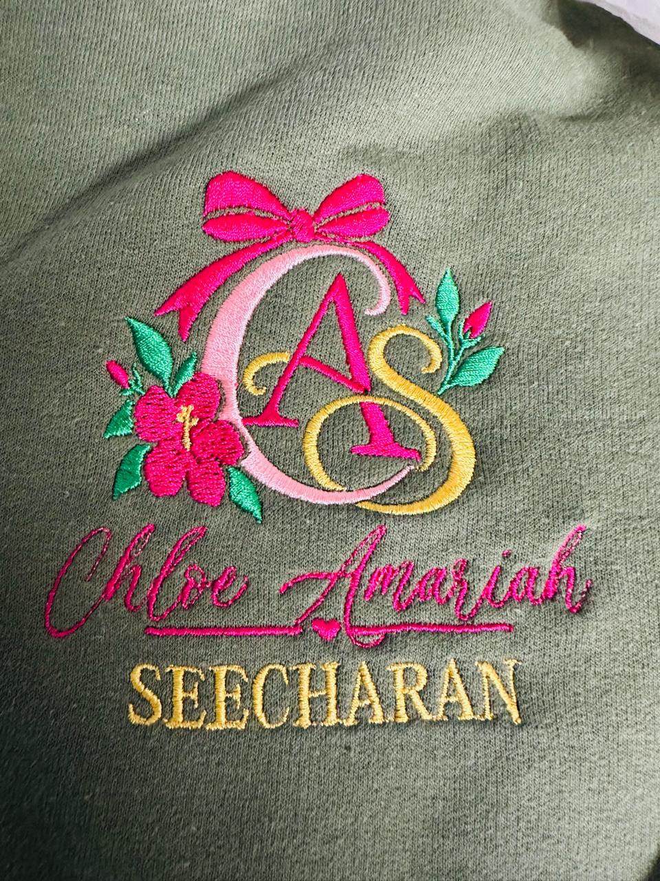 Pink, yellow and green floral monogram with embroidered personalisation on olive fabric.