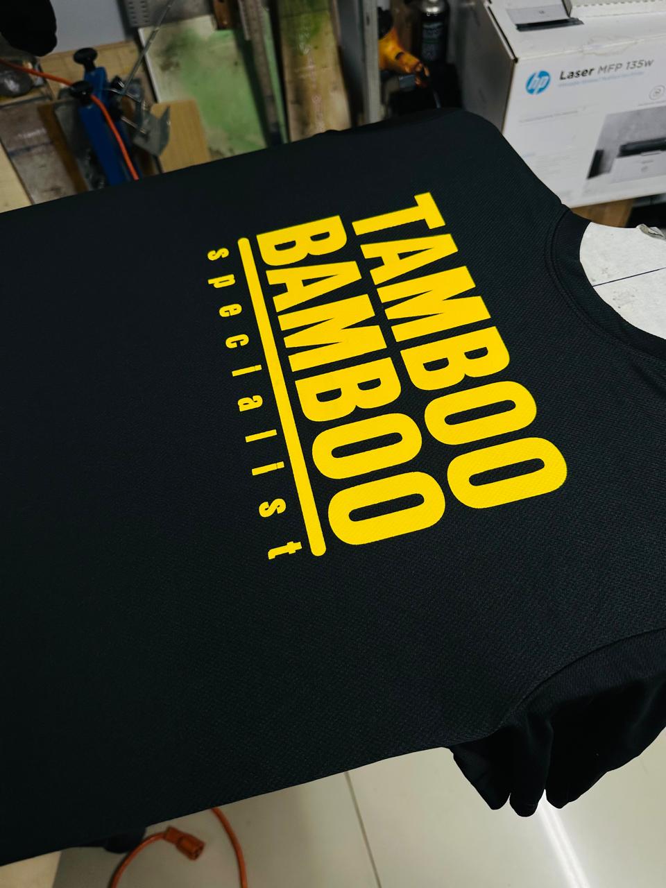 Black garment with large yellow Tamboo Bamboo Specialist lettering.